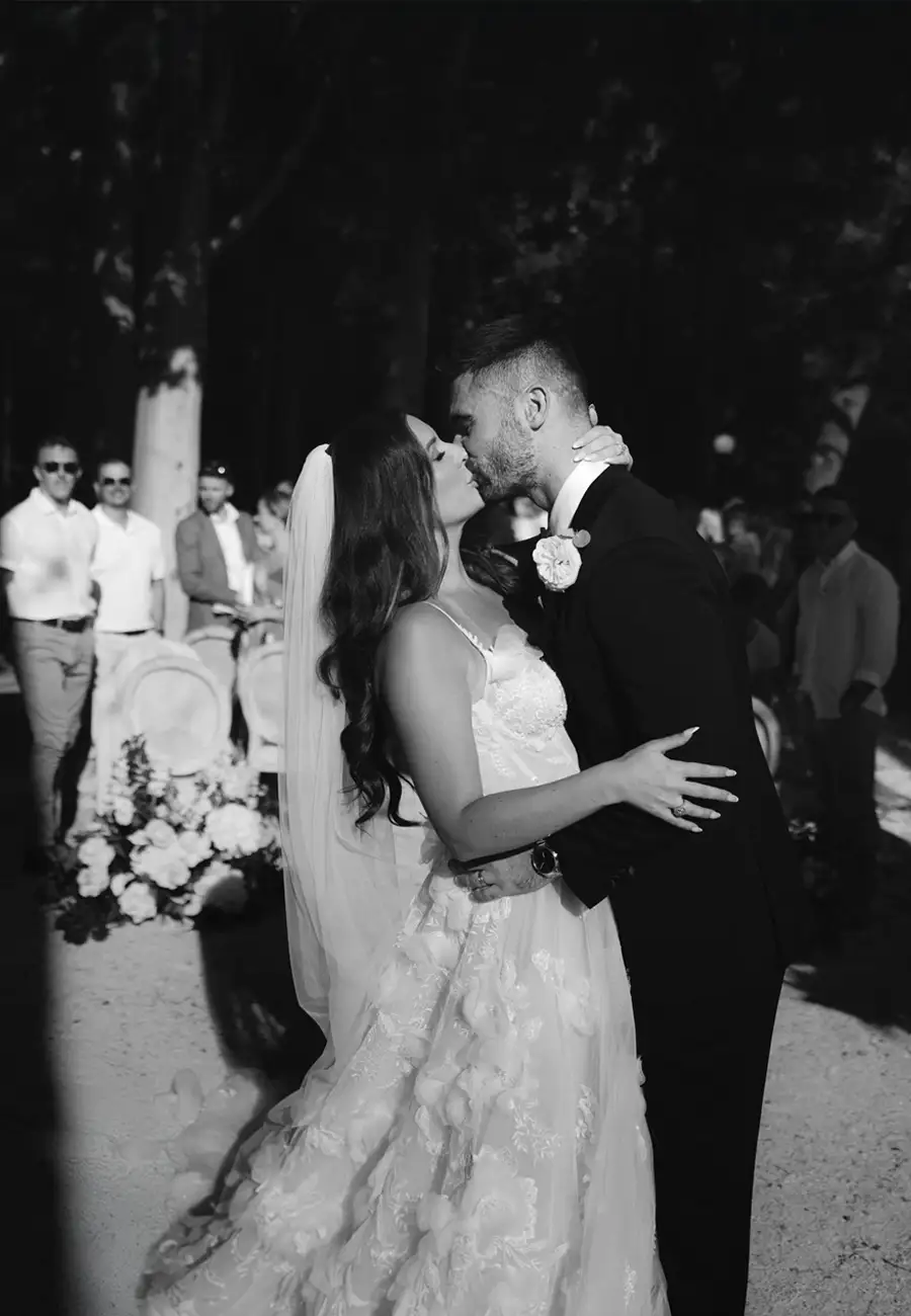 Black and white, Molly and Alex kissing in the ceremony aisle, rows of chairs behind, Villa Dalmacija, Split