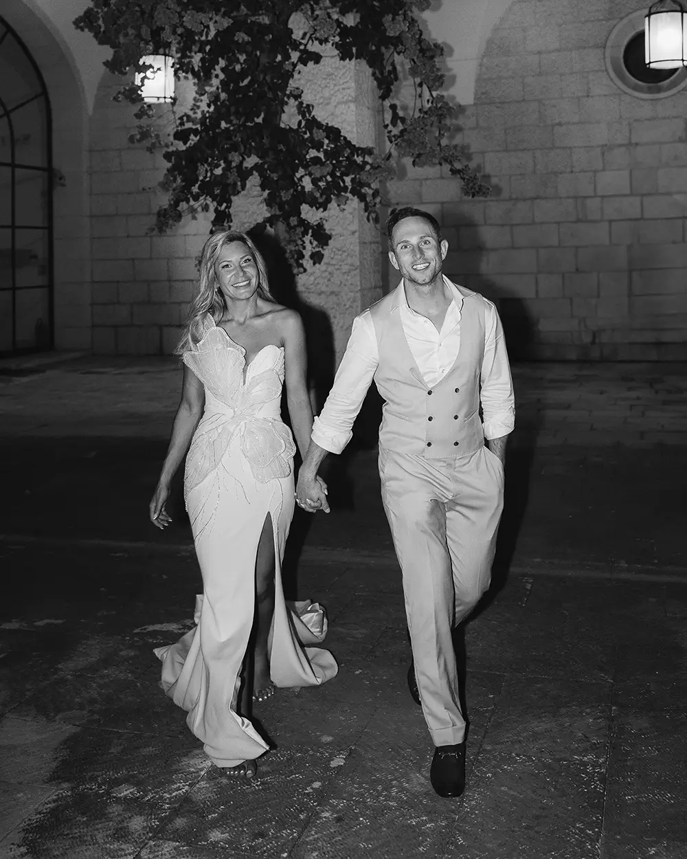 Black and white, couple walking hand in hand at night past lit lanterns, MOMA, Dubrovnik