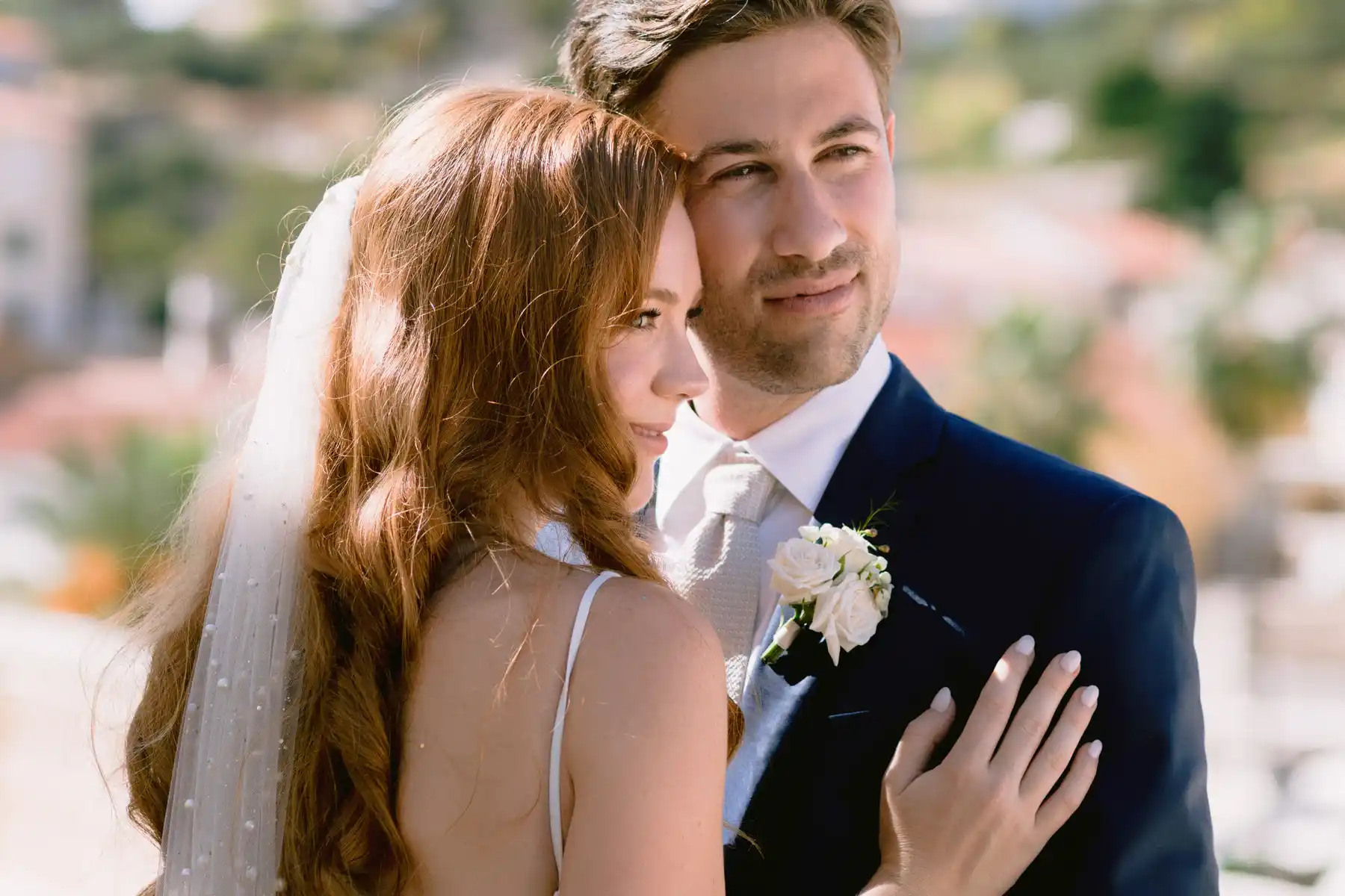 She stands with her back half turned, her veil rim-lit, he rests his head against hers, Hvar.
