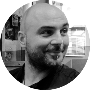That's me: a bald man with a short beard, smiling and looking to my right in a black and white photo. Hello to you!