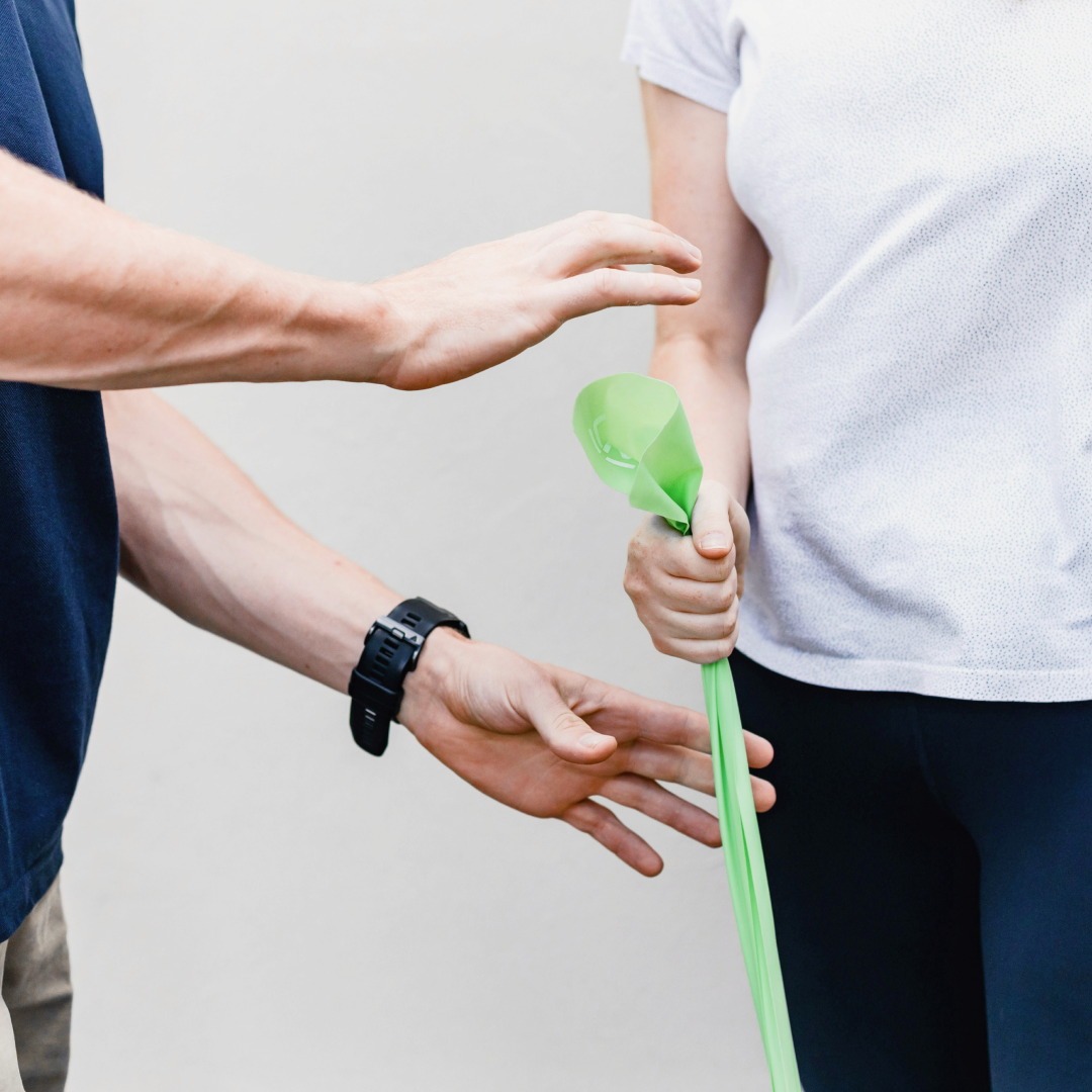 physio helping client with resistance band