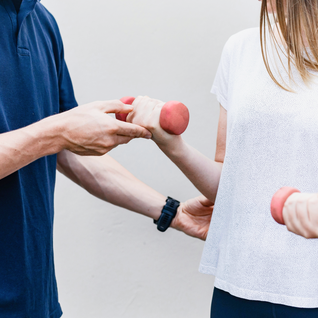 physio helping client with weights