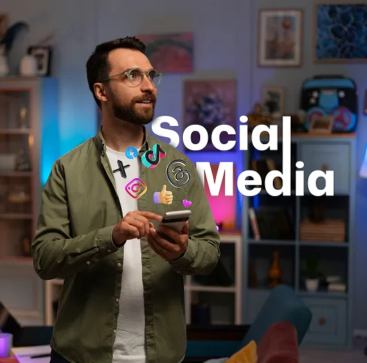 A man standing in a room holding a cell phone.