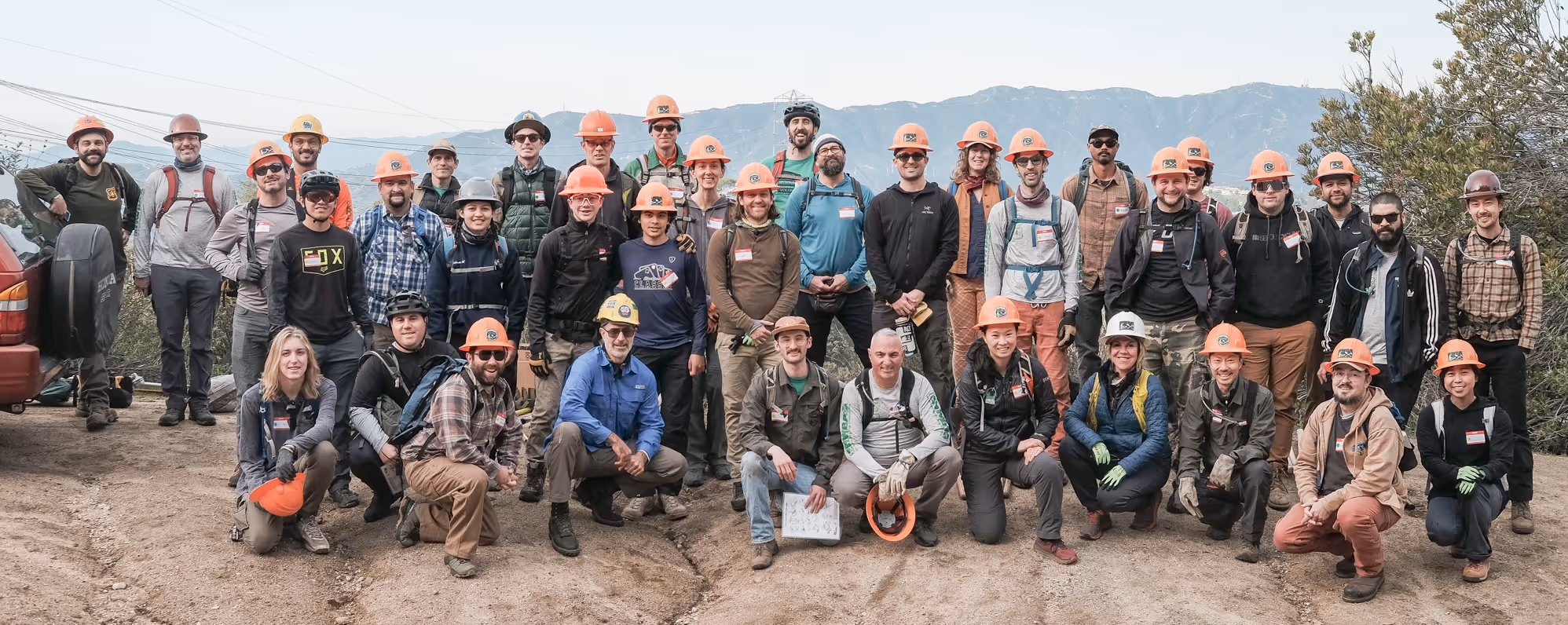 MWBA team photo on a trail, with mountains in the background