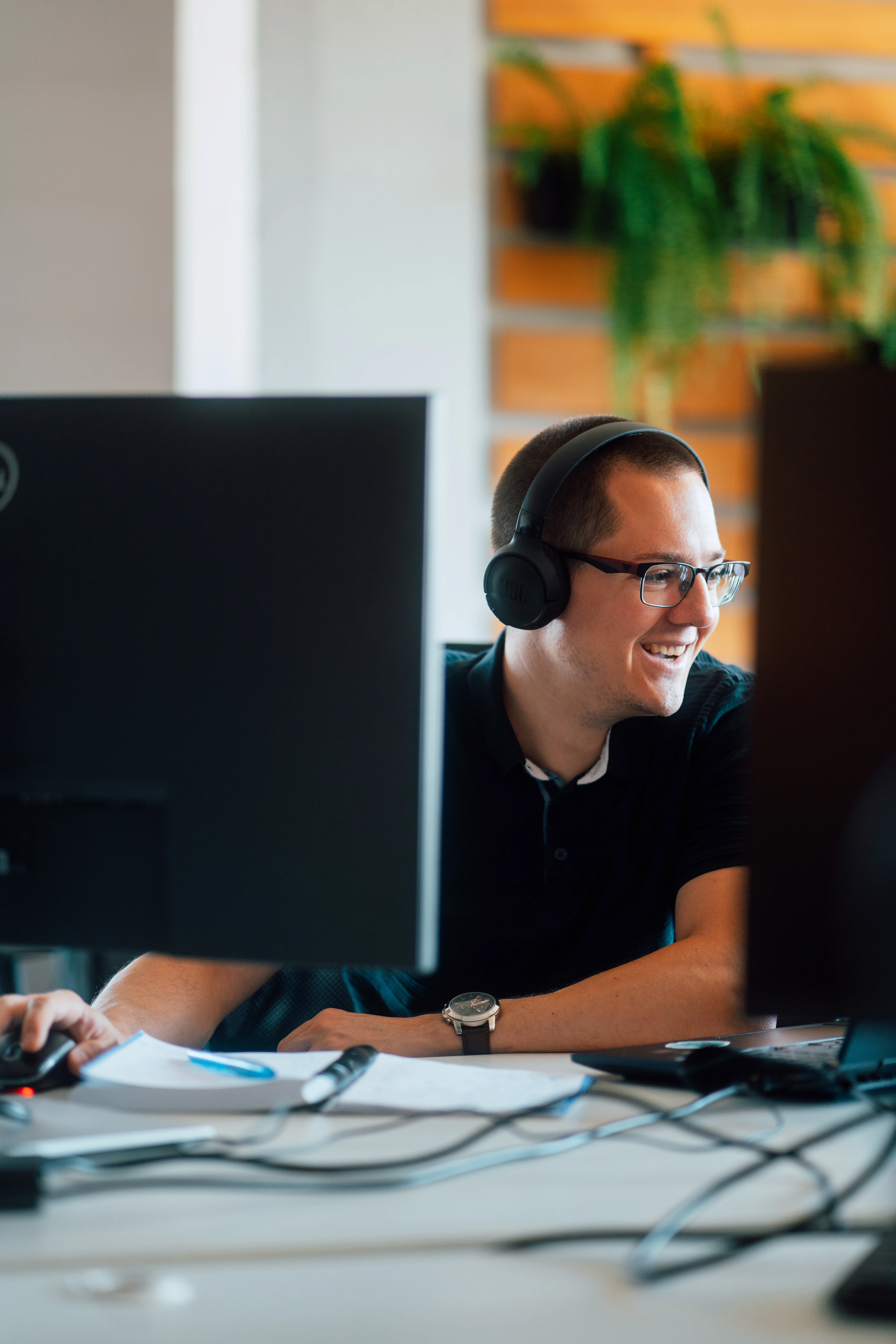 Smiling Galeyo developer working with headset in modern office setting
