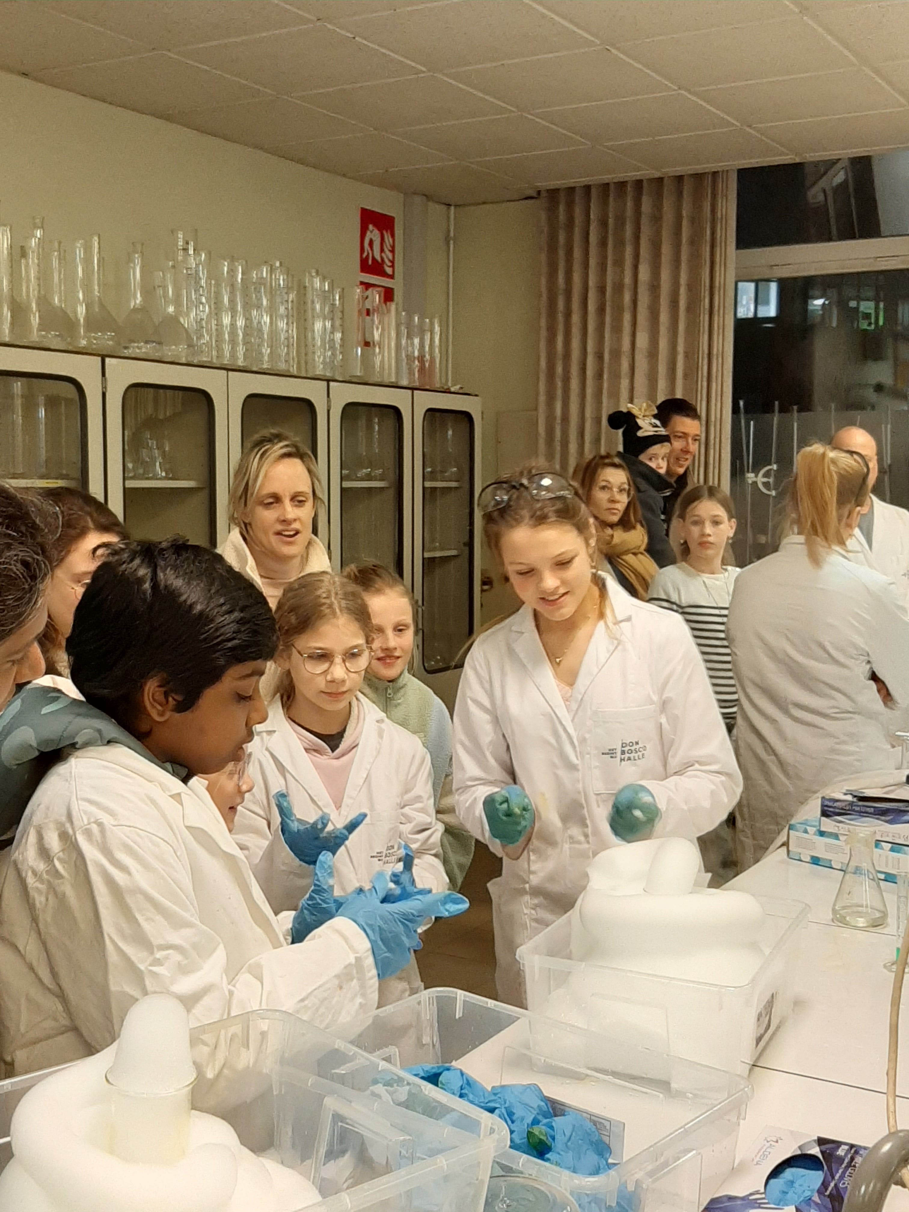 leerlingen wetenschappen tonen enkele proeven aan bezoekers