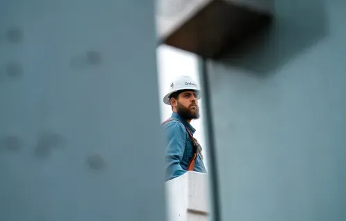 Lineman in gridware hat looking on the pole construction