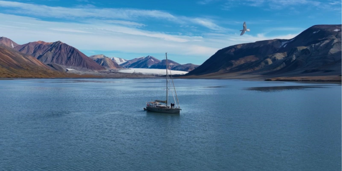 Garcia Exploration 52 Lifexplorer at anchor near Bylot Island in the Canadian Arctic during the Northwest Passage, surrounded by mountains and glaciers.