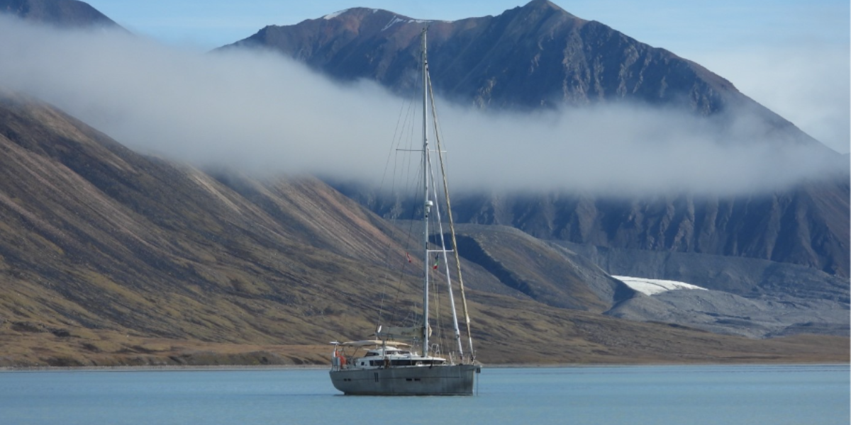 Garcia Exploration 52 Lifexplorer at anchor in the Canadian Arctic during the 2026 Northwest Passage, surrounded by mountains and glaciers.