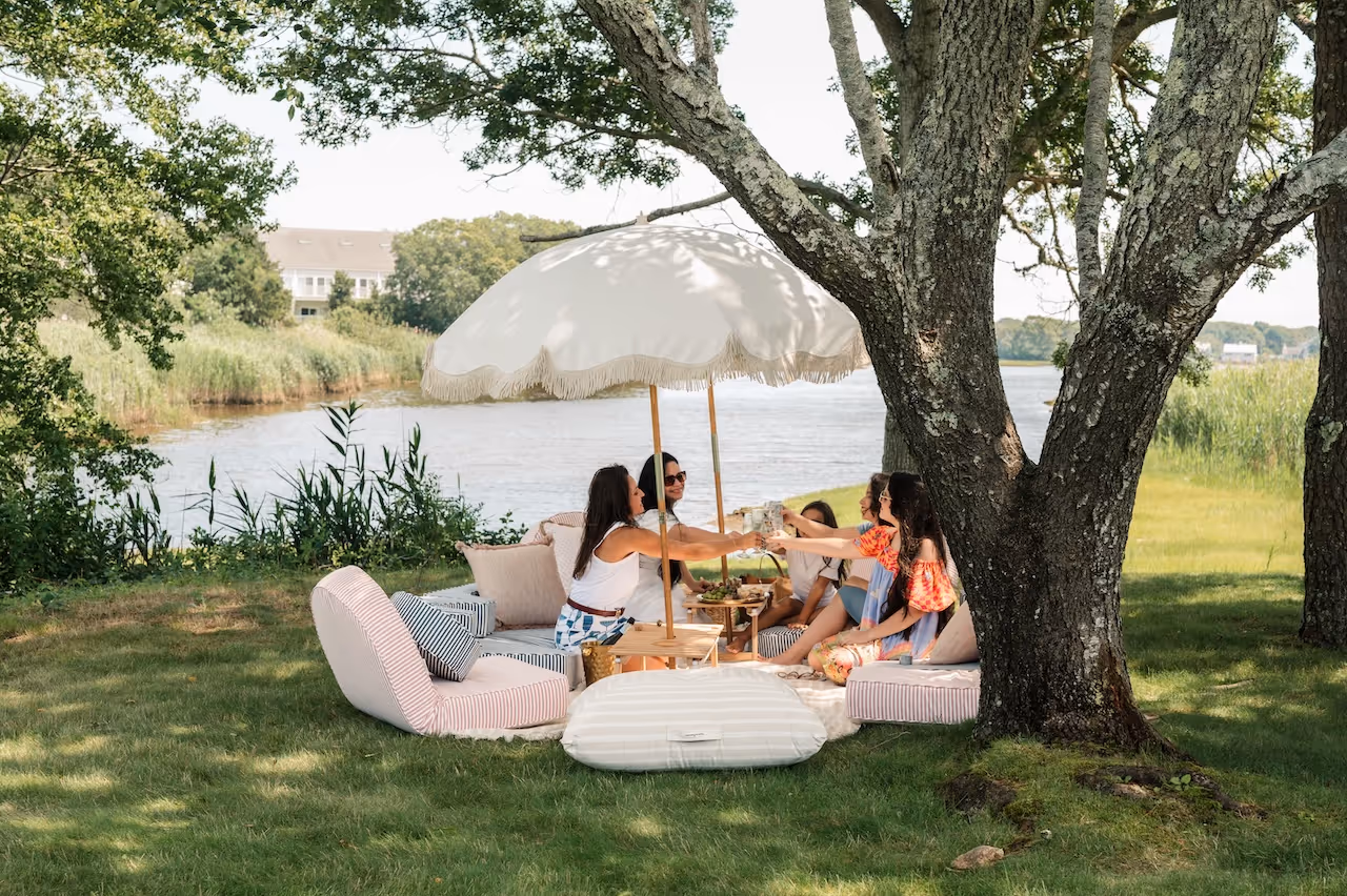 A group of women enjoying drinks on the banks of a creek