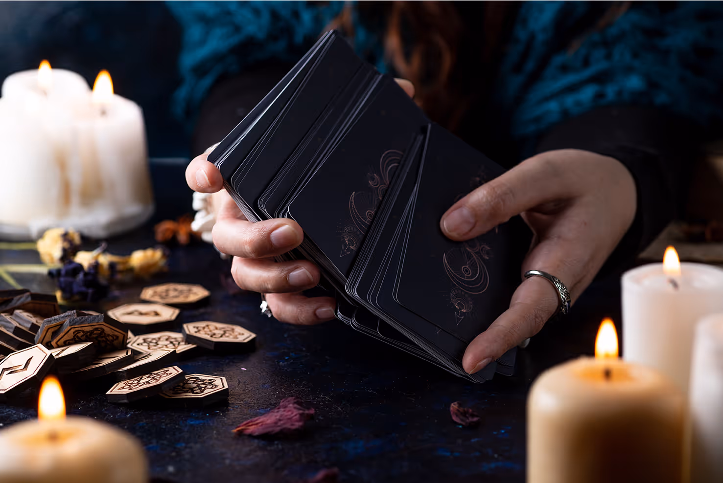 Hands holding a deck of tarot cards.