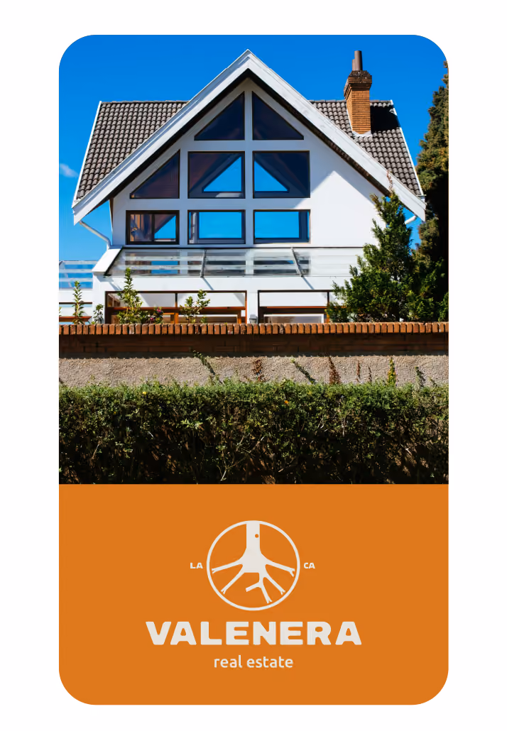 Modern house with large triangular windows under a tiled roof and surrounding greenery, with Valenera real estate logo below.