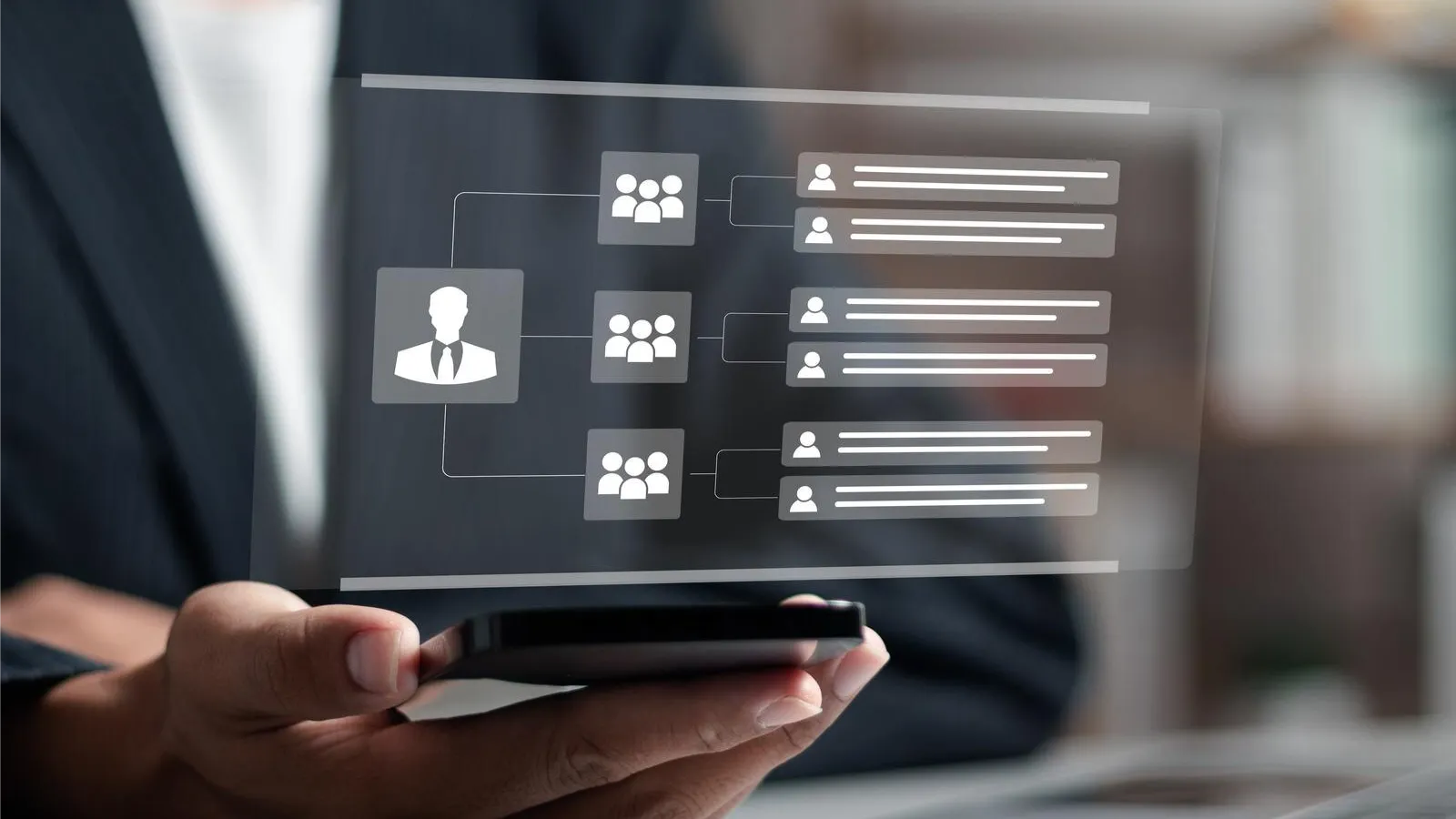 A person in business attire holds a smartphone displaying a digital organizational chart. The transparent screen interface symbolizes cloud-based retail communication tools facilitating team management and hierarchy in small businesses.