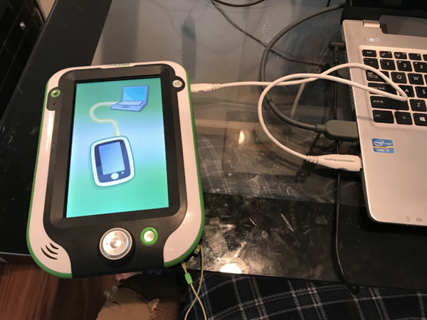 LeapPad Ultimate connected to a computer via USB cable.