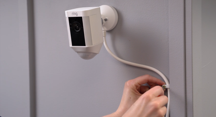 Securing power cable onto wall with provided clips.