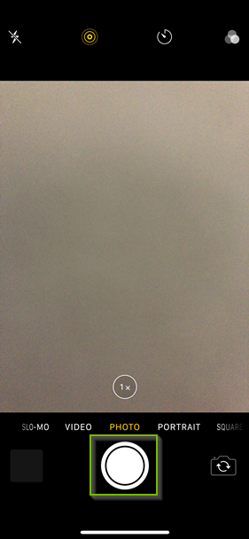 iPhone camera app with the shutter button highlighted.