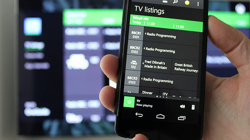 Xbox one being controlled by a smartphone using the Smartglass app. Illustration.