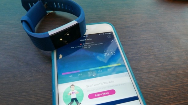 Fitbit Charge 2 laying next to a mobile device.