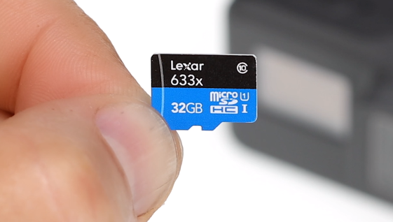 A microSD card held by fingertips.