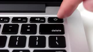 keyboard with person pointing to the power button on the keyboard