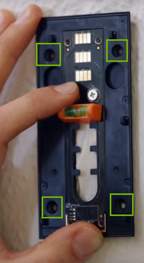 Backplate against wall with mounting holes highlighted