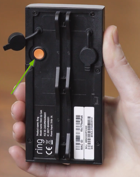 Rear protective cover removed, exposing orange setup button.