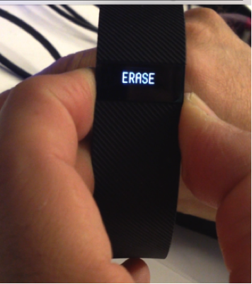 Fitbit Charge with ERASE on screen.