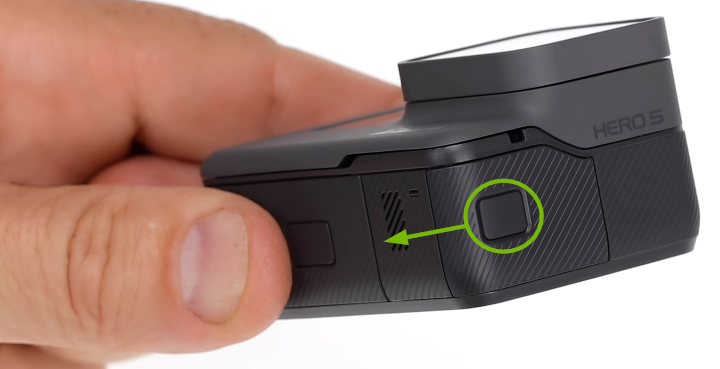 Connectors compartment door release button highlighted on side of camera