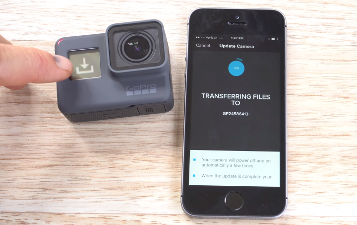 GoPro HERO6 displaying its update process, and a smartphone displaying it processing update files wirelessly to the GoPro.