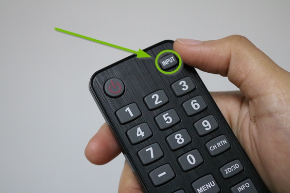 Television remote highlighting the input button.