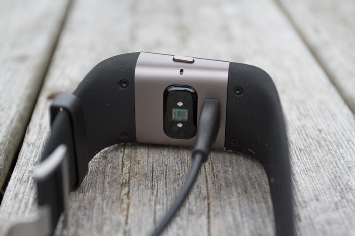 Fitbit Surge plugged in to charge with the supplied USB cable.