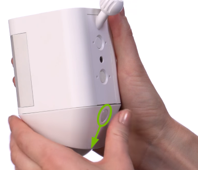 Release button highlighted on battery compartment door of Ring Camera.