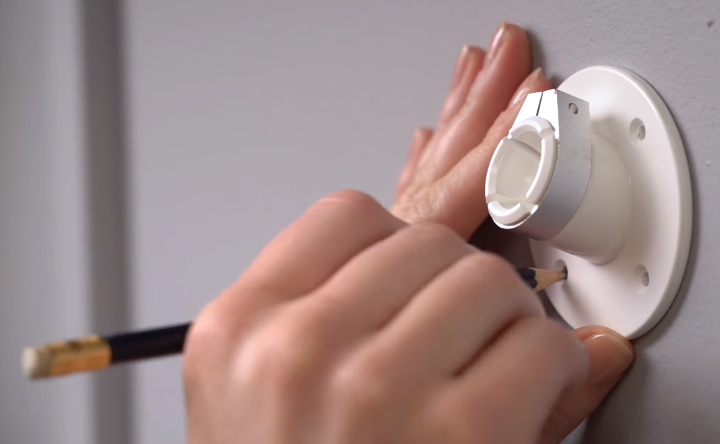 Marking holes on wall using camera camera mounting bracket.