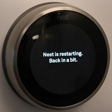Nest thermostat performing a restart operation.