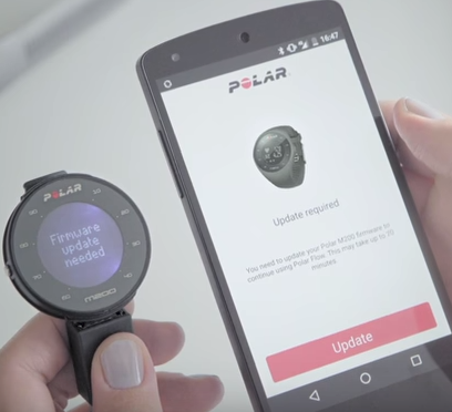 A polar m200 fitness tracker next to an android phone showing that an update is required