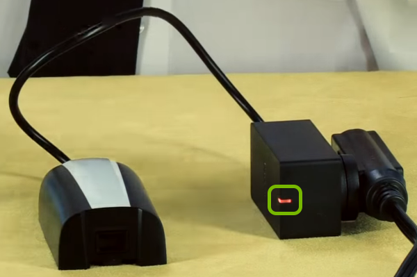 Battery charge indicator light highlighted on charger.