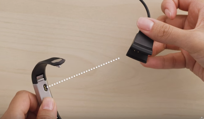 Connecting the charger to the Fitbit.