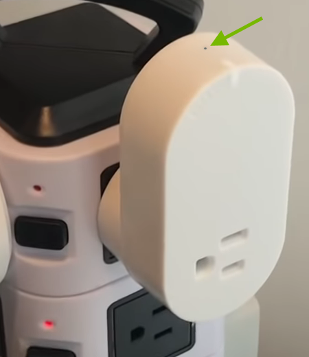 Arrow pointing out reset pinhole on side of control outlet.