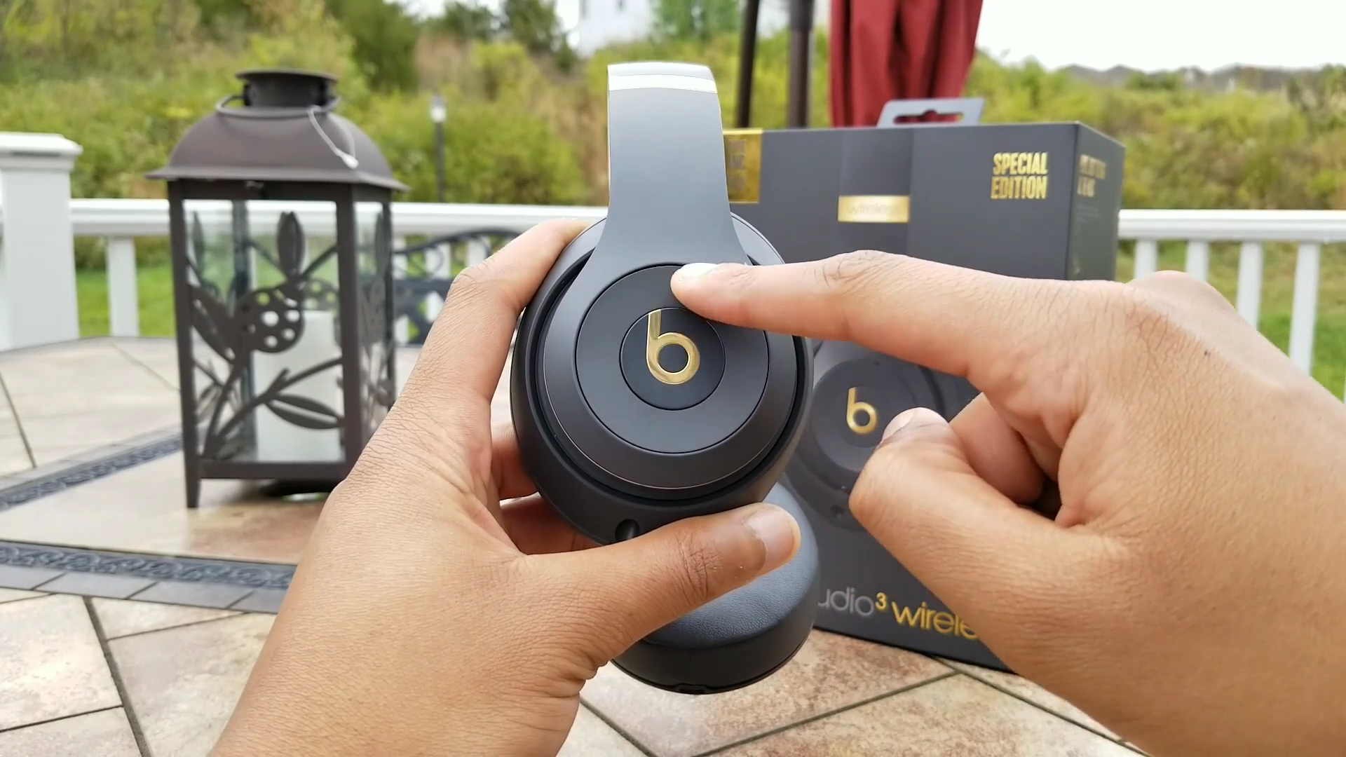 person holding headphones with the finger on the volume button