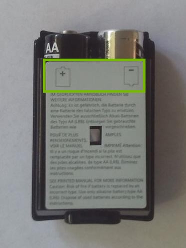 Xbox 360 wireless controller battery compartment highlighting battery orientation.