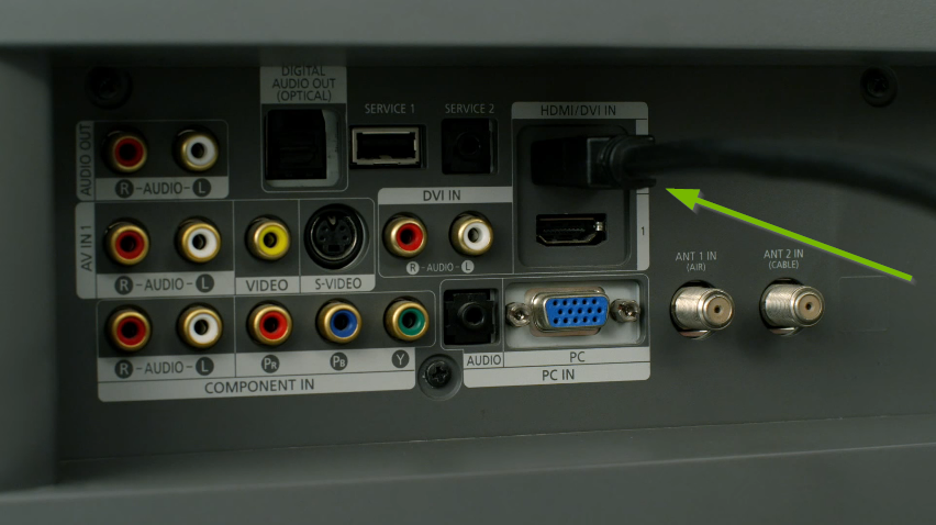 Connecting an HDMI cable to the rear of a TV set.