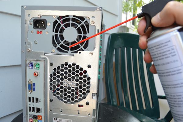 Using gas duster to clean computer vents.