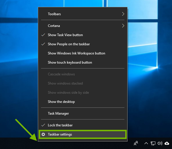 Empty spot pointed out on Windows taskbar and Taskbar settings highlighted in context menu.