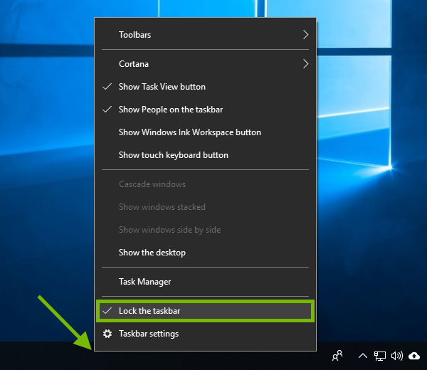 Empty spot pointed out on Windows taskbar and Lock the taskbar highlighted in context menu.