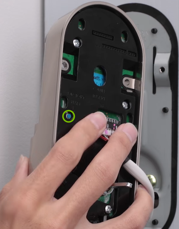 Reset button highlighted on back of door lock.