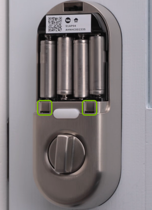 Holes holding the battery cover tabs annotated on door lock.