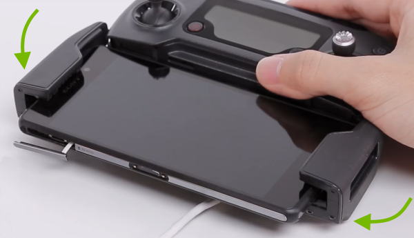 Mobile device being inserted into remote controller clamps.