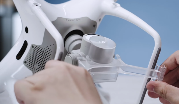 Gimbal cover being removed from drone.