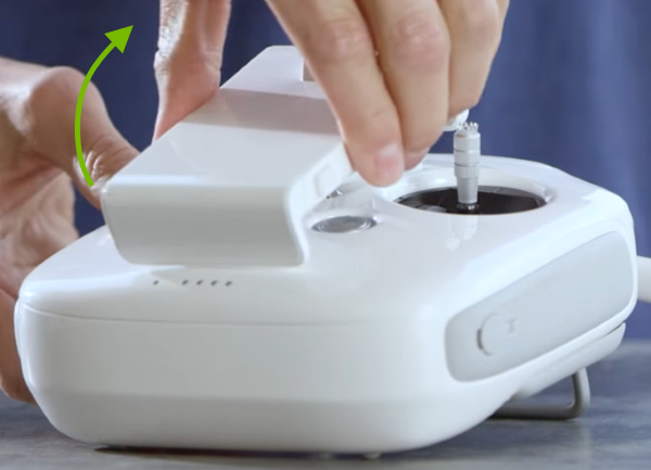 Mobile device holder on remote control being unfolded.