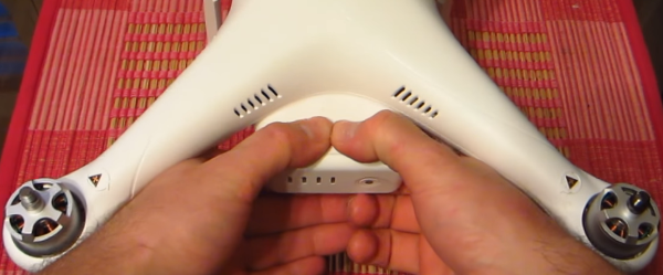 Placement of hands shown for easy battery removal procedure.